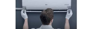 Technician installing a wall-mounted air conditioning unit
