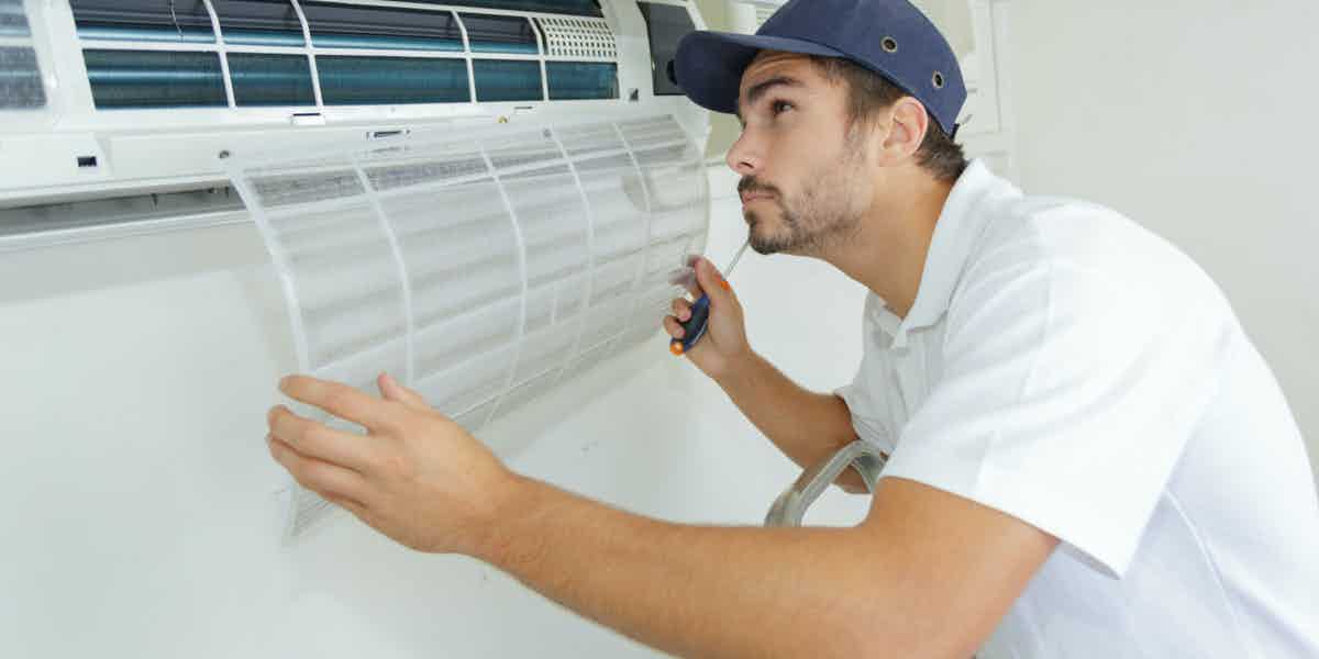 Technician inspecting an indoor air conditioning unit