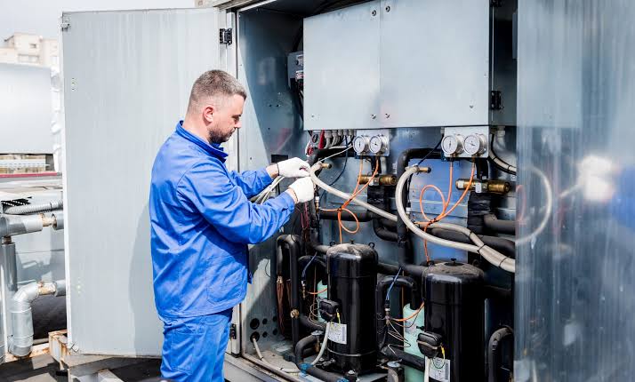 HVAC technician inspecting heating and cooling system components