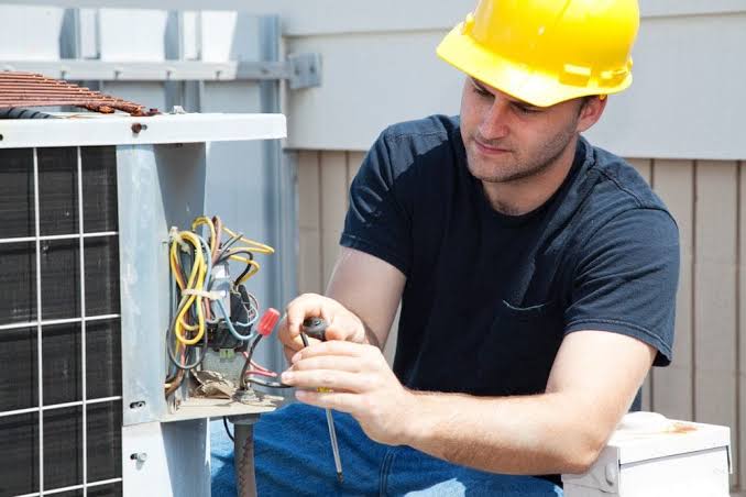 HVAC technician servicing a residential outdoor air conditioning unit